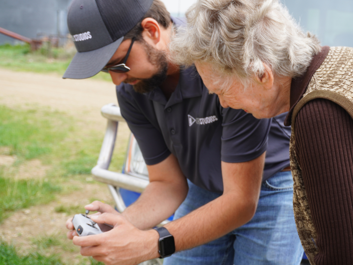 Rancher Sally Austin watches real-time drone footage as Riley Slivka, AgriStudios, videos her ranch.